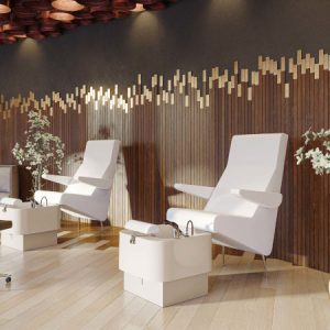 Moderner Spa-Bereich mit luxuriösen Pediküre-Stühlen vor stilvoller Holzwand und Dekoration.