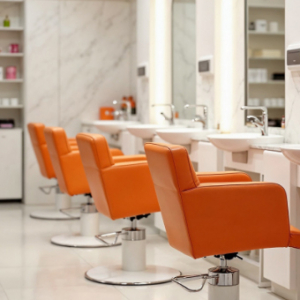 Eine Reihe von orangefarbenen Friseurstühlen.